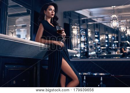 Gorgeous Young Brunette Woman In Dark Dress With Wine