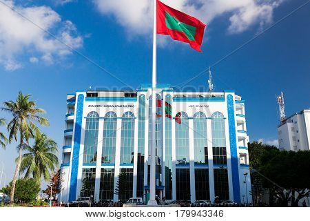Male, Maldives - December 17, 2016: Shaheedh Hussain Adam Building And Flag Of Maldives In Centre Of