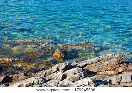 Close-up of transparent deep blue sea water rocky coast and rocky bottom. Bozava Croatia summer
