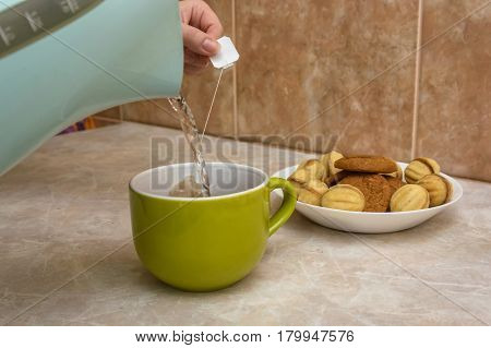 Teapot and cups are prepared for tea drinking at home