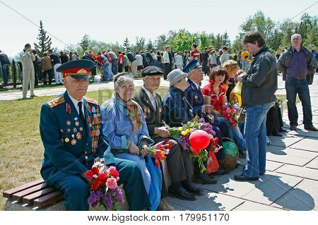 Volgograd Russia - May 09 2008: World War II veterans sit on the bench with flowers on the Mamaev Kurgan in Volgograd