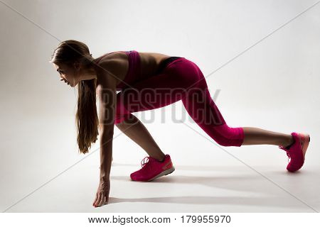 A Woman Dressed In Sportswear Prepared To Run. Studio. White Background.