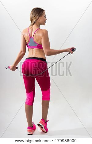Woman In Sportswear Holding A Rope In His Hands. White Background. Studio.