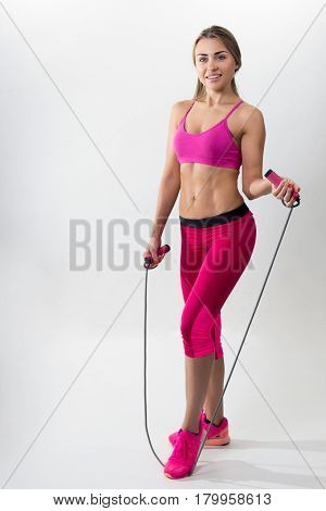 Woman In Sportswear Holding A Rope In His Hands. White Background. Studio.