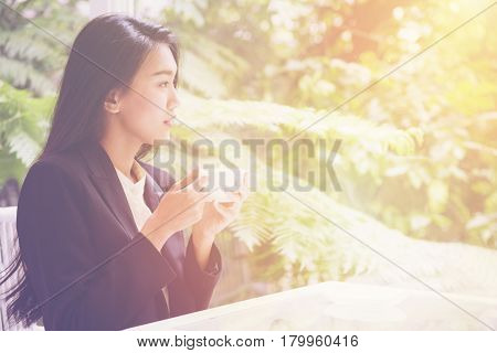 Woman drinking tea and using tablet in coffee shop for summary of Business performance report