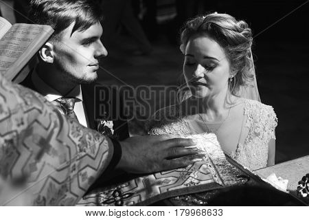 wedding ceremony at church. stylish groom and bride exchanging wedding rings and giving vows. spiritual sensual moment.