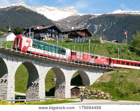 Surselva Switzerland - May 14 2015: Bridge of the Rhaetian Railway in the Surselva valley. The deck is illuminated by the sun during a beautiful day on the day of the Feast of the Ascension.