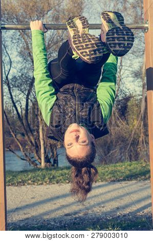 Athletic Female Doing Exercise At Outdoor Fitness Pullup Bar Station.