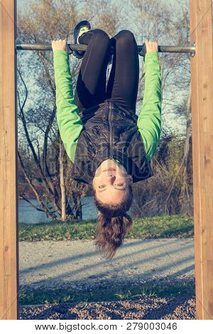 Athletic Female Doing Exercise At Outdoor Fitness Pullup Bar Station.