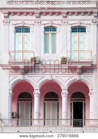 Neoclassical architecture with column in pale rose with white door and pillars in Vedado Havana in Cuba