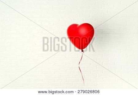 Red Ballon With Heart Shape Hangs Aganst White Wall
