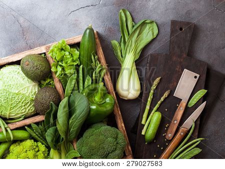 Assorted Green Toned Raw Organic Vegetables In Wooden Box On Dark Stone Background. Avocado, Cabbage