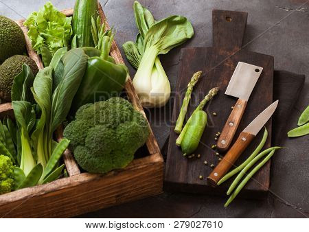 Assorted Green Toned Raw Organic Vegetables In Wooden Box On Dark Stone Background. Avocado, Cabbage