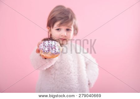 Portrait Of A Little Girl With A Donut In Her Hands