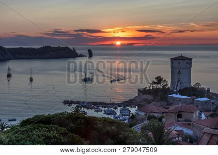 Beautiful Seascape At Sunset With A Lighthouse And Boats. Giglio Island (isola Del Giglio), Tuscany,