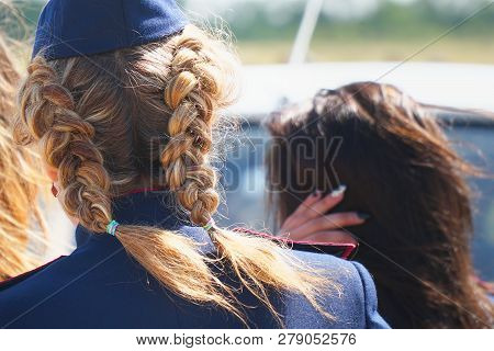 Woman With Pigtails In Uniform In A Forage-cap. Rear View