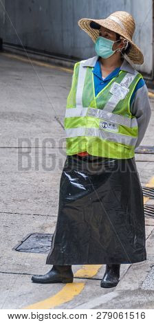 Hong Kong, China  - May 12, 2010: Female Traffic Warden At Parking Exit With Fluorescent Yellow Jack