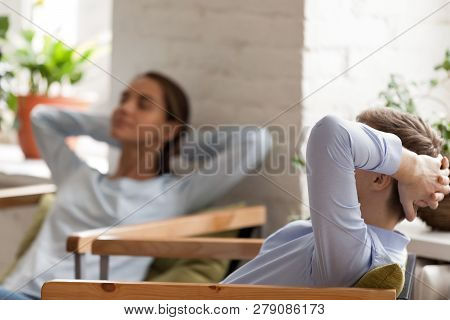 Tired Businessman Relaxing Leaning Back In Armchair With Colleag