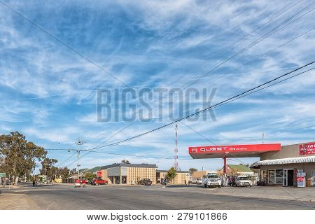 Carnavon, South Africa, August 31, 2018: A Street Scene, With Vehicles, People And Businesses, In Ca