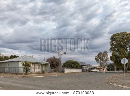 Carnavon, South Africa, September 1, 2018: An Early Morning Street Scene, With Old Houses And Windmi