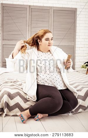 Overweight Young Woman Disband Her Ginger Hair From Tail