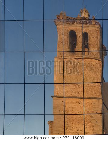 Parish Church Of San Pedro Apostol Reflected On Glass Building, Montijo, Badajoz, Spain. Key Rural D