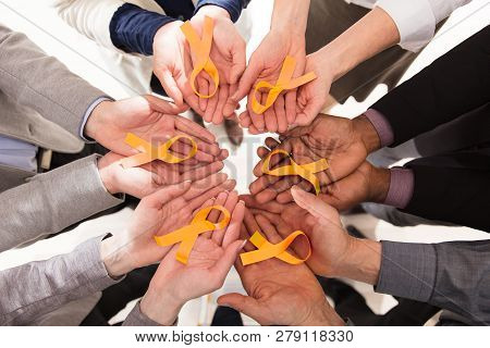Group Of Businesspeople Holding Teal Ribbons To Support Childhood And Bladder Cancer