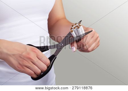Quit Smoking Closeup Of Womens Hands Holding A Bunch Of Cigarettes And Cut Them Into Halves Of Sciss