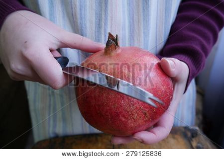 Man Cuts A Ripe Pomegranate With A Knif - Close-up