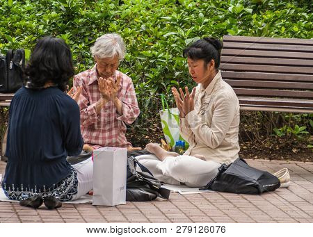 Hong Kong, China  - May 13, 2010: Kowloon Park, Tsim Sha Tsui. Three Women Take Time To Meditatie An