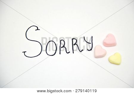 The Inscription On The Paper Sorry And A Number Of Candies In The Shape Of A Heart, Selective Focus