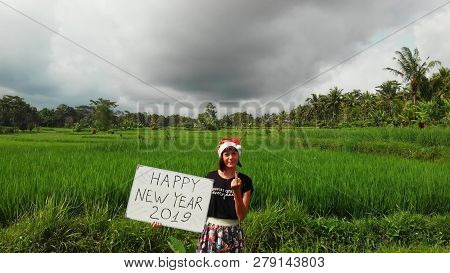 Woman Showing Middle Finger. Happy New Year 2019 Joke On Bali Island. Handwritten Text On Whiteboard