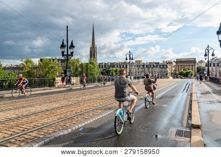 Bordeaux, France - July 22, 2018: Scenic View Of Pont De Pierre Bridge With Cyclists A Rainy Day Of 