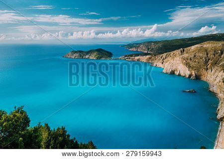 View Of Kefalonia West Coastline. Assos Village Town And Frourio Peninsular. Beautiful Milky Blue Ba