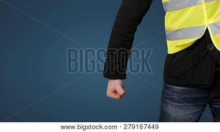 Yellow Vests Protests. Unrecognizable Man Clenched His Fist In Protest On Blue Background. Concept O
