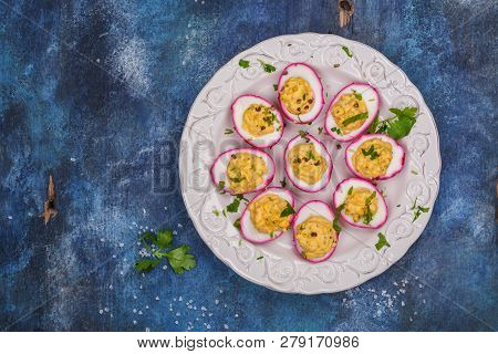Beet-dyed Deviled Eggs. Easter Stuffed Eggs On Blue Background. Copy Space
