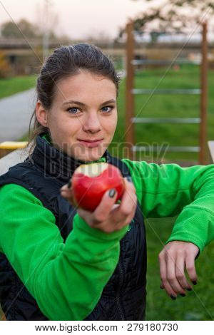 Fitnes Trainer Offering An Apple At Outdoor Gym.