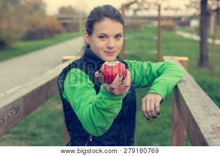 Fitnes Trainer Offering An Apple At Outdoor Gym.