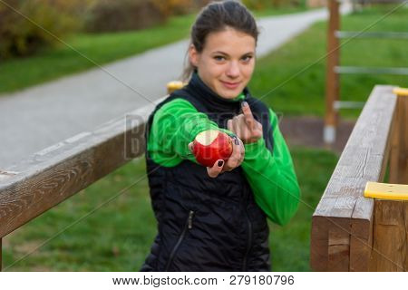 Fitnes Trainer Offering An Apple At Outdoor Gym.