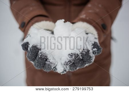 A Girl Holds A Handful Of Snow In Her Hands, Who Are Wearing Gray Gloves With A Resouce