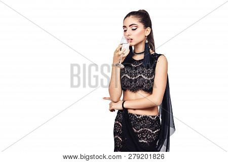 Elegant Young Girl Holding A Glass Of Champagne Near The Mouth. Isolated On White