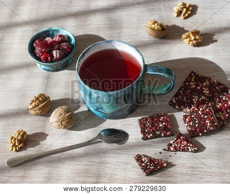 Raspberry Tea, Chocolate, Nuts And Raspberries On A Wooden Table, Selective Focus.