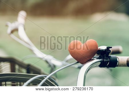 A Little Red Heart Pillow On The Bicycle Handlebar.