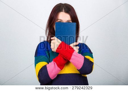 Scared Young Woman Hiding Her Identity And Face Behind A Book Holding Crossed Hands Like An Introver