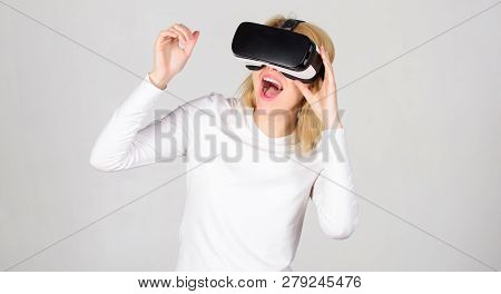Woman Using Vr Device. Woman Wearing Virtual Reality Goggles In Grey Background. The Woman With Glas