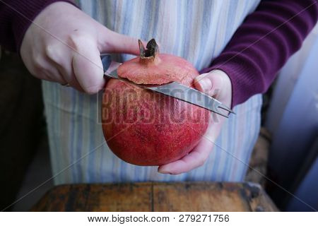 Man Cuts A Ripe Pomegranate With A Knif - Close-up