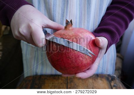 Man Cuts A Ripe Pomegranate With A Knif - Close-up