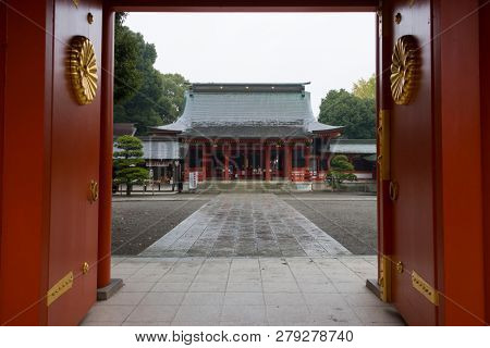 Kumamoto, Japan - November 12, 2018: Main shrine of Fujisaki Hachiman Shrine seen through the gate with golden chrysanthemum 
