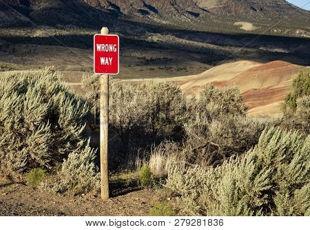 A Sign Indicating You Are Going The Wrong Way That Is In The Middle Of The Desert.