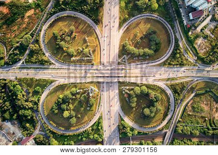 An Aerial Shot Of A Motorway With Cloverleaf Overpass. The Motorway Is Filled With Traffic But Not C
